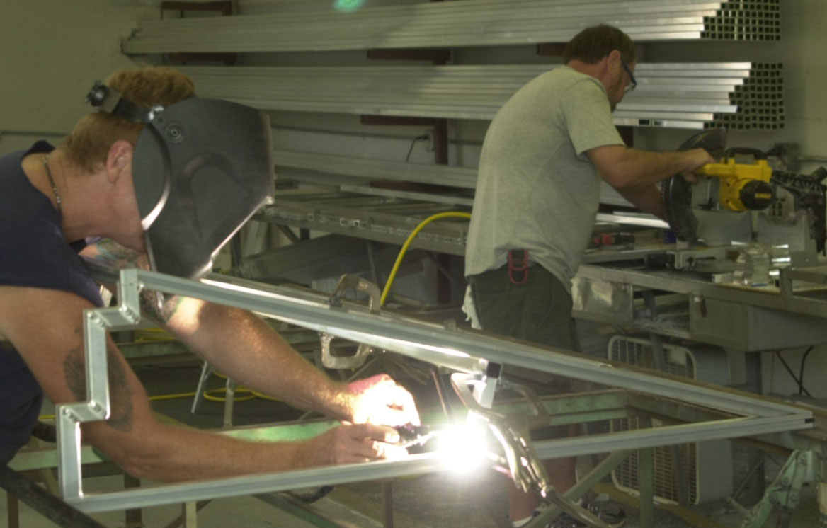 PitchEquipment fabrication shop floor with welders working on aluminum equipment